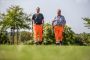 Zwei Arbeiter mit orangenen Arbeitshosen beim Nordic-Walking