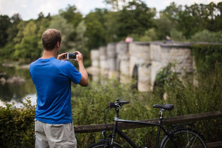 Ein Radfahrer macht mit seinem Smartphone ein Foto der markanten Kanzelbrücke am Möh-nesee. Sie ist einer der neu geschaffenen Fotospots entlang des MöhnetalRadwegs.