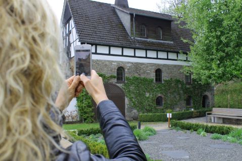 Eine junge Dame fotografiert das Kunsthaus Alte Mühle in Schmallenberg.